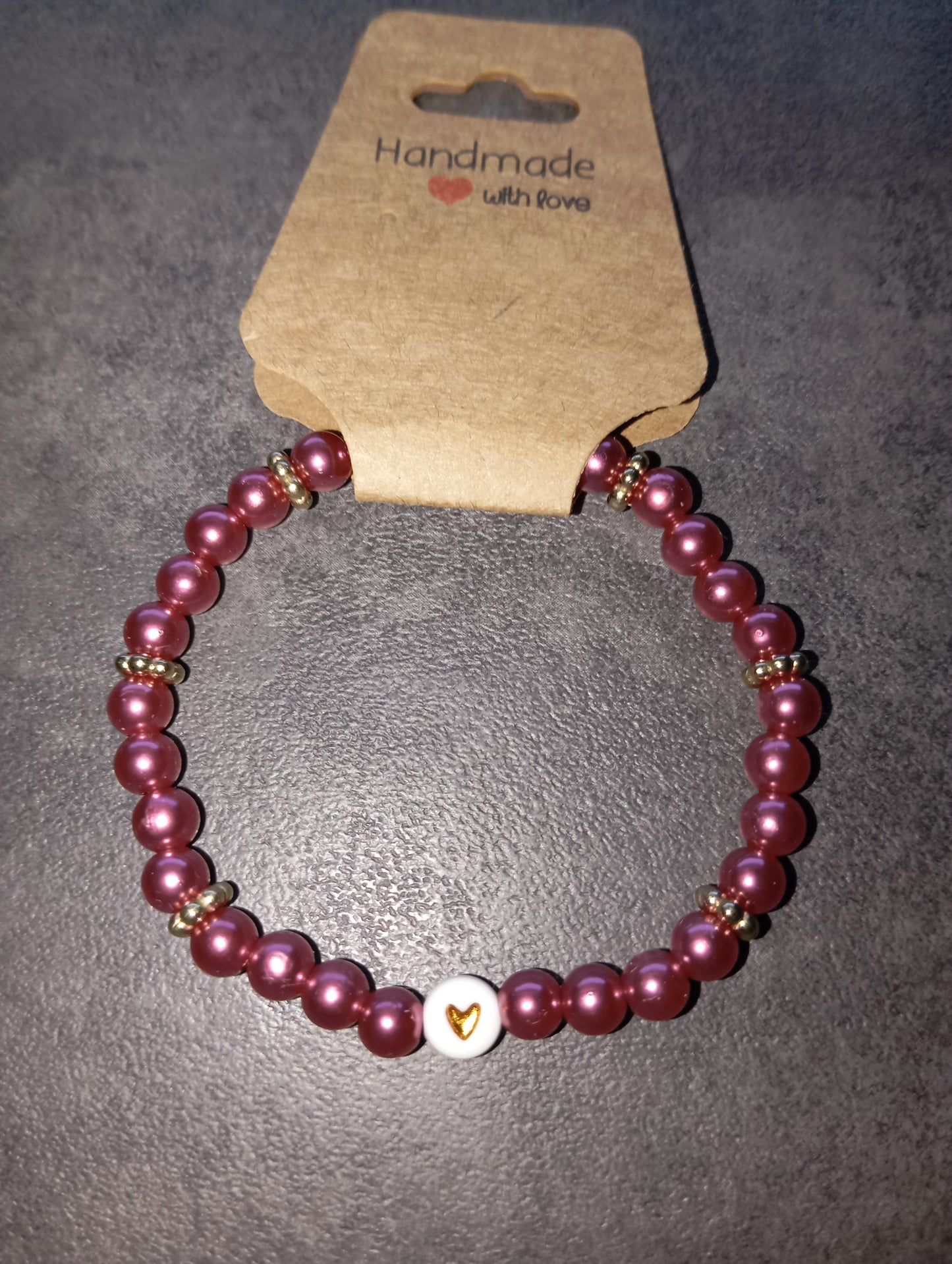 Armband dunkelpink mit goldenen Herz