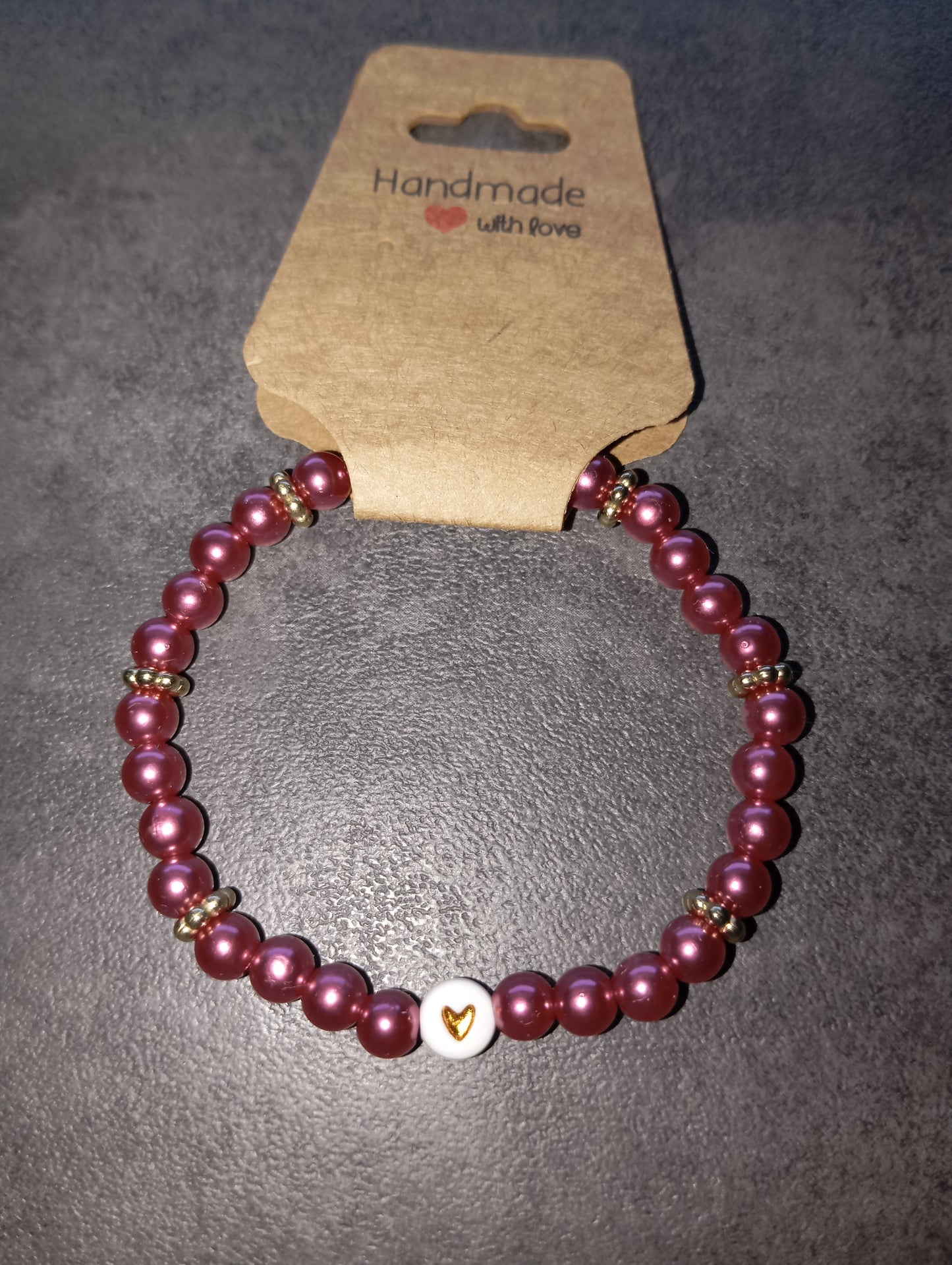 Armband dunkelpink mit goldenen Herz